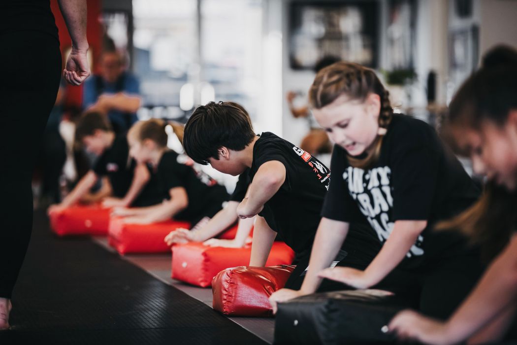 Students training with protective equipment during a Krav Maga class